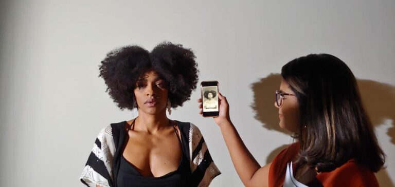 Pessoa da produção mostra a foto de referência da personagem à atriz