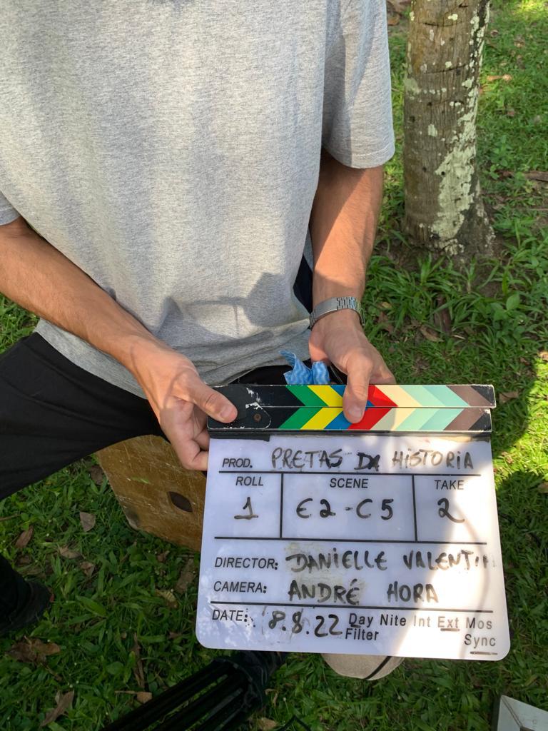 Person holding a clapperboard from the project Pretas da História